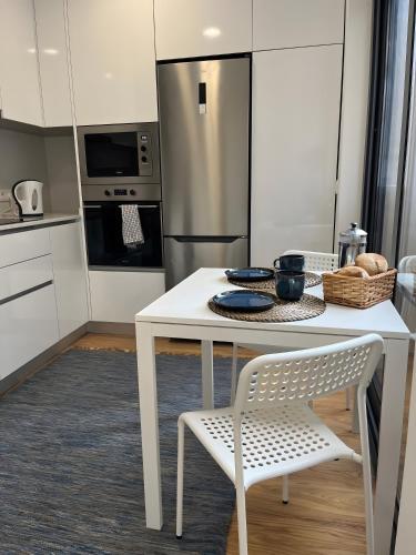 a kitchen with a white table and a refrigerator at Flor de Sá in Aveiro