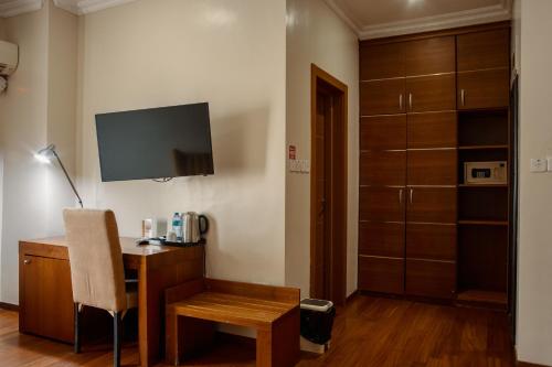 a room with a desk with a chair and a tv at Morning Side Suites in Lagos
