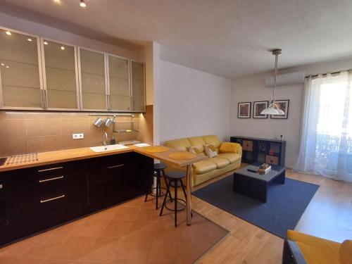 a kitchen and living room with a couch and a table at Belvárosi apartman in Gyöngyös