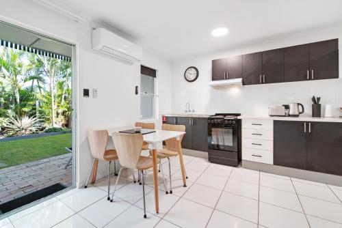 a kitchen with a table and chairs in a house at Beachcomber Peregian Beach in Peregian Beach
