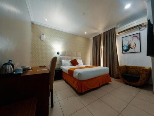 a hotel room with a bed and a desk at Morning Side Suites in Lagos