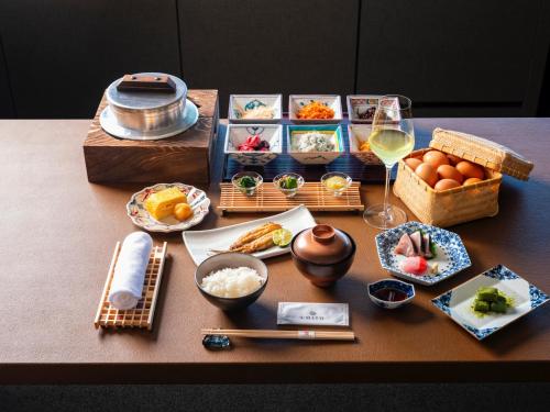 a table topped with food and a glass of wine at UMITO Atami Bettei in Atami