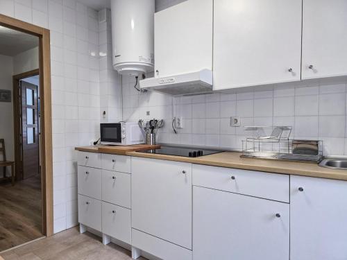 a kitchen with white cabinets and a counter top at Casa Taro San Vicente de la Barquera in San Vicente de la Barquera
