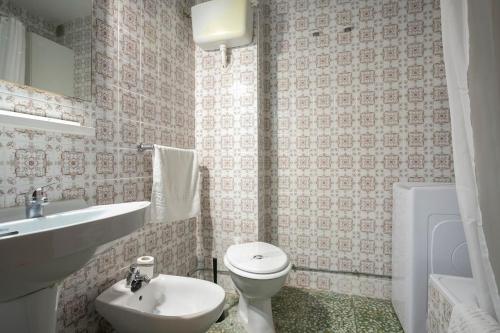 a bathroom with a white toilet and a sink at Casa Taro San Vicente de la Barquera in San Vicente de la Barquera