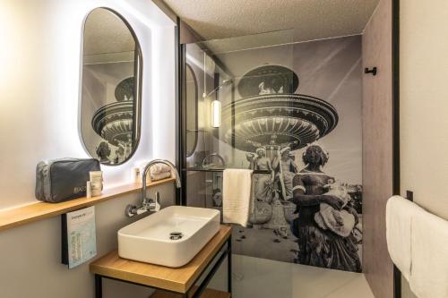 a bathroom with a sink and a mirror at Campanile Evry Est - Saint Germain les Corbeil in Saint-Germain-lès-Corbeil