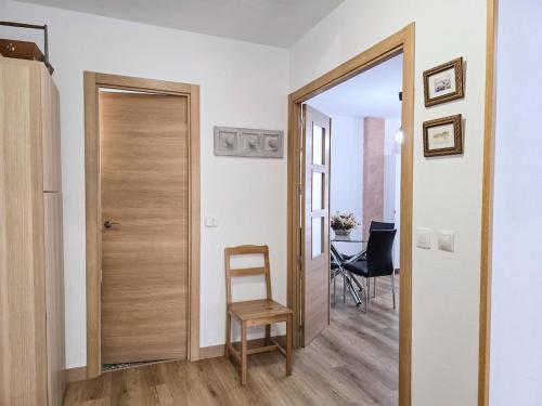 a hallway with a door and a chair and a table at Casa Taro San Vicente de la Barquera in San Vicente de la Barquera
