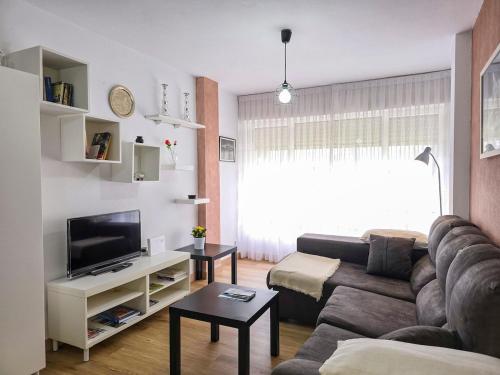 a living room with a couch and a tv at Casa Taro San Vicente de la Barquera in San Vicente de la Barquera
