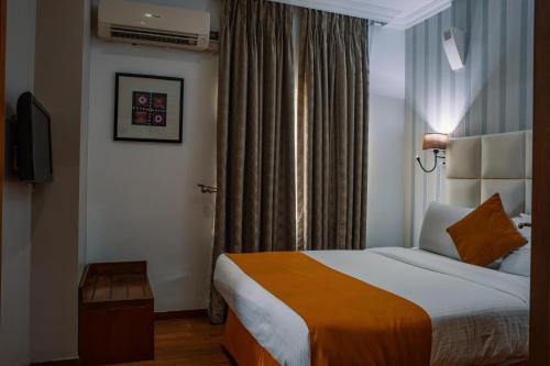 a hotel room with a bed and a window at Morning Side Suites in Lagos