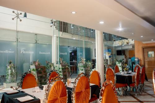 a dining room with tables and orange chairs at Morning Side Suites in Lagos