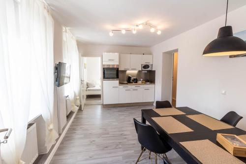 a kitchen and dining room with a table and chairs at AugsburgLiving - Business- und Ferienapartments in Augsburg