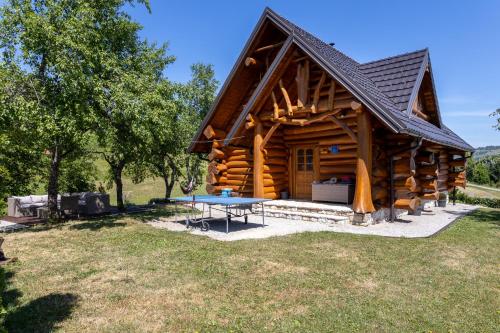a log cabin with a table in front of it at BeaR's LOG in Seliste Dreznicko