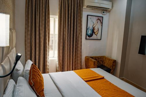 a hotel room with a bed and a window at Morning Side Suites in Lagos