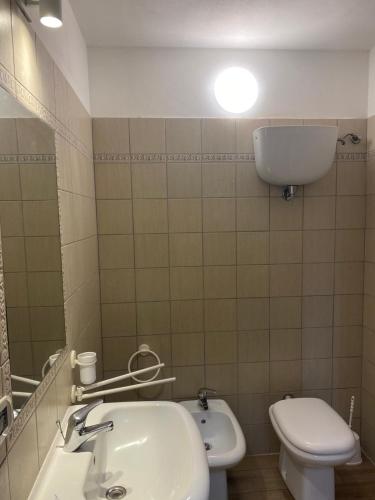 a bathroom with a sink and a toilet and a mirror at Frattina1860 in Montisi