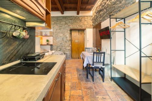 a kitchen with a stove and a dining room with a table at Angolo Medioevale - Como Centro in Como