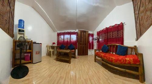 a living room with two beds and a refrigerator at A&C Aquino Guesthouse in Moalboal