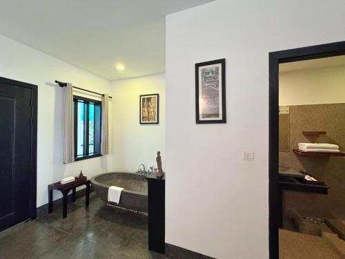 a bathroom with a bath tub and a sink at The Bliss Angkor in Siem Reap