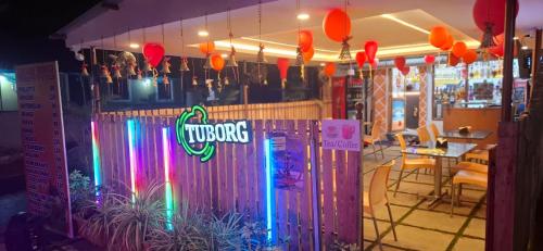 a restaurant with a bar with a neon sign at Ave Maria Guesthouse in Colva