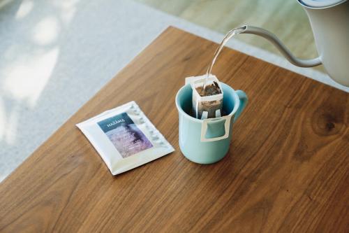 a table with a cup with a book and a lamp at 1NLDK hyuga in Hyuga