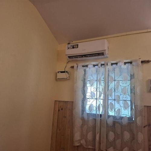 a room with a window with a air conditioner at Ave Maria Guesthouse in Colva