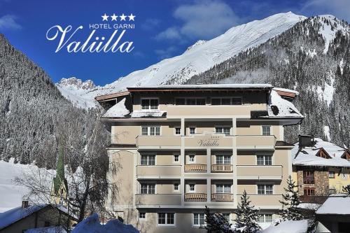 a building in front of a snow covered mountain at Hotel Garni Valülla in Ischgl