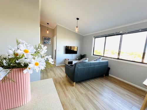 a living room with a blue couch and a large window at Affordable Luxury Stay Near Manly Beach in Sydney
