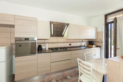 a kitchen with white cabinets and a table with chairs at Bright Villa with Balcony and Jacuzzi, Milan Area in Cesate