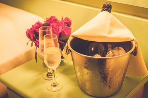 a bottle of wine in a bucket next to two glasses at Real NOB Hotel in Orleans