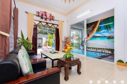 a living room with a couch and a table at Villages Hồ Bơi Võ Thị Sáu Lô Góc gần Quảng Trường in Vung Tau