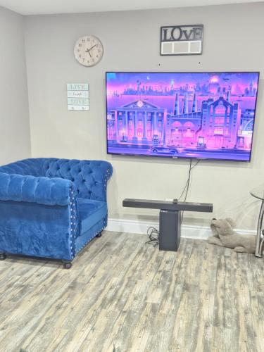 a living room with a blue couch and a tv at Beautiful 3 bedrooms, 2 bathrooms, 4 beds sleep 8, basement close to Falls in Niagara Falls