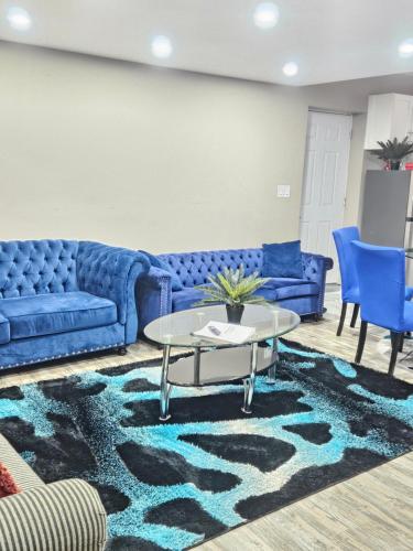 a living room with blue couches and a table at Beautiful 3 bedrooms, 2 bathrooms, 4 beds sleep 8, basement close to Falls in Niagara Falls