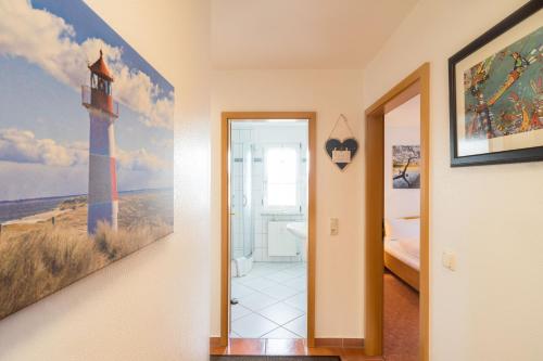 a hallway with a room with a lighthouse painting on the wall at Inselhaus Whg 03 in Stubbenfelde