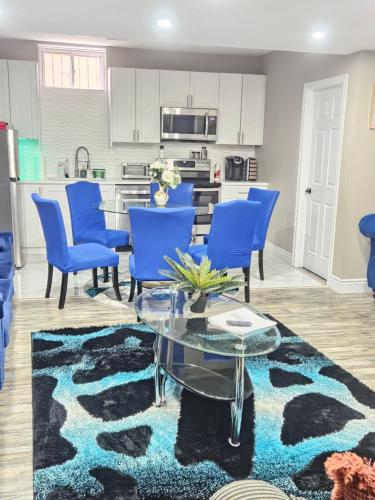 a kitchen and living room with blue chairs and a table at Beautiful 3 bedrooms, 2 bathrooms, 4 beds sleep 8, basement close to Falls in Niagara Falls
