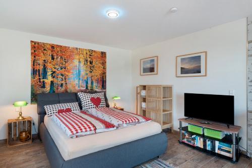 a bedroom with a bed with a large painting on the wall at Ferienwohnung Weitblick in Sasbachwalden