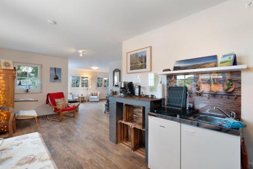 a kitchen with a sink and a living room at Ferienwohnung Weitblick in Sasbachwalden