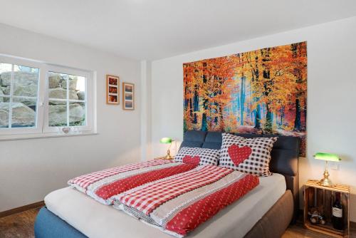 a bedroom with a bed with a large painting on the wall at Ferienwohnung Weitblick in Sasbachwalden