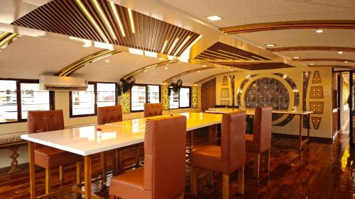 une salle à manger avec une longue table et des chaises dans l'établissement Sharing Back Water, à Alappuzha