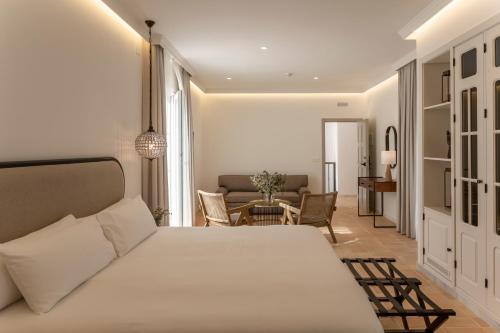 a bedroom with a bed and a living room at Albariza Hotel Boutique in Sanlúcar de Barrameda