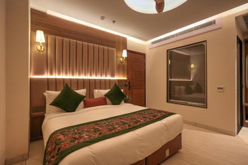 a bedroom with a large bed with green pillows at RC Dream Palace in Greater Noida