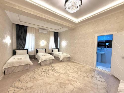 a hotel room with two beds and a chandelier at Status Inn Hotel in Samarkand