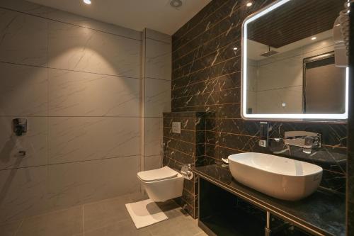 a bathroom with a sink and a toilet and a mirror at RC Dream Palace in Greater Noida
