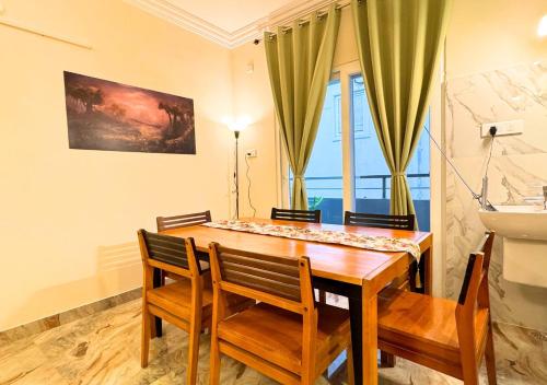 a dining room with a wooden table and chairs at Evara Grand Vista - Fully Equipped 3BHK near AMB in Hyderabad