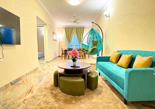 a living room with a blue couch and a table at Evara Grand Vista - Fully Equipped 3BHK near AMB in Hyderabad
