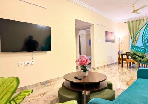 a living room with a blue couch and a table at Evara Grand Vista - Fully Equipped 3BHK near AMB in Hyderabad