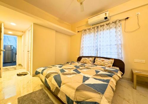 a bedroom with a bed in front of a window at Evara Grand Vista - Fully Equipped 3BHK near AMB in Hyderabad