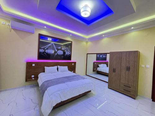 a bedroom with a large bed and a blue ceiling at VIP Djuba Guest in Fombeni