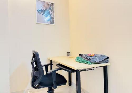 a desk with a black chair and a wooden table at Evara Grand Vista - Fully Equipped 3BHK near AMB in Hyderabad