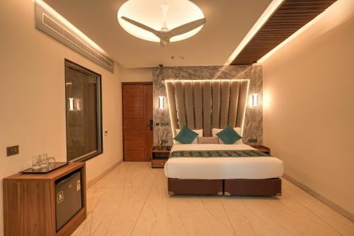 a bedroom with a king sized bed and a television at RC Dream Palace in Greater Noida