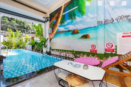 a room with a mural of a beach and a swimming pool at Hoàng My Villa Hồ Bơi Bãi Sau căn Góc in Vung Tau
