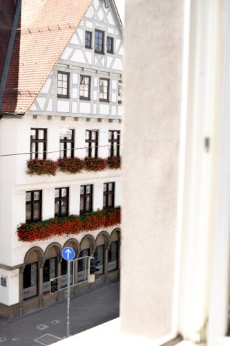un edificio bianco con balcone fiorito di Boutique Apartment LIMONIA - Historic Heart of Ulm a Ulma