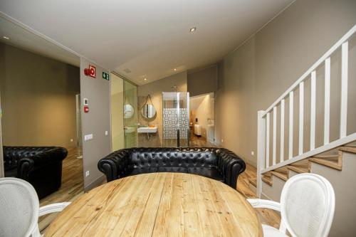 a dining room with a table and black leather furniture at Les Clarisses Boutique Hotel in Vic